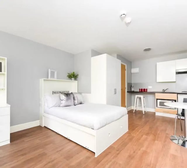 White bed cabinet kitchen counter and stools studio apartment at Tramways in Chester Student Accommodation