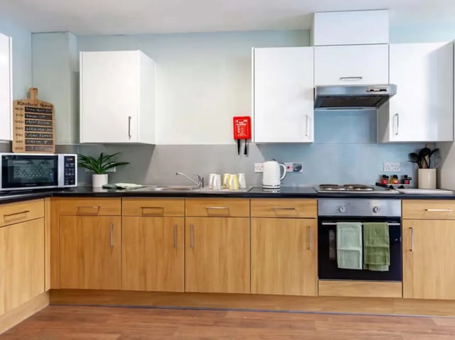 Microwave kettle oven wooden cabinets kitchen at Llys Y Deon in Bangor Student Accommodation