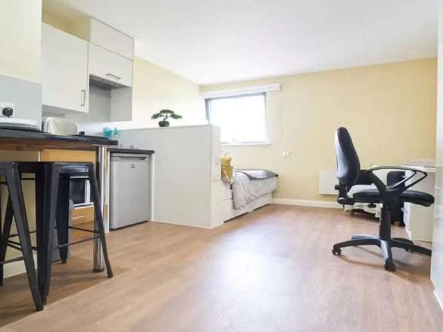 Bed fridge desk chair and counter studio apartment at Llys Y Deon in Bangor Student Accommodation