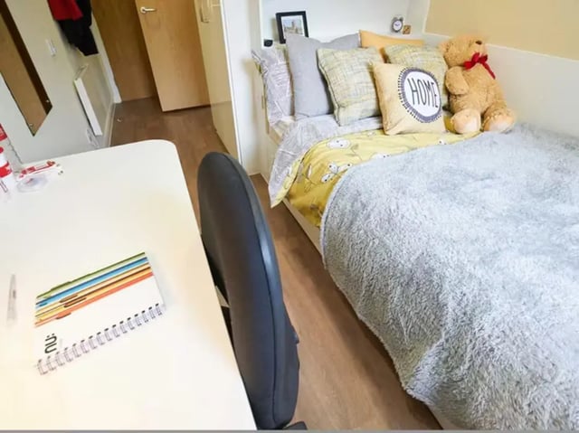 Bed desk chair and pillows bedroom at Llys Y Deon in Bangor Student Accommodation