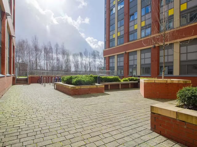 Brick paved courtyard with bike racks and benches exterior at Collegelands in Glasgow Student Accommodation