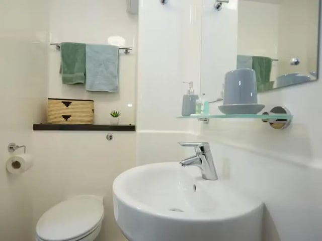 Toilet sink towels basket plant soap dispenser bathroom at Collegelands in Glasgow Student Accommodation