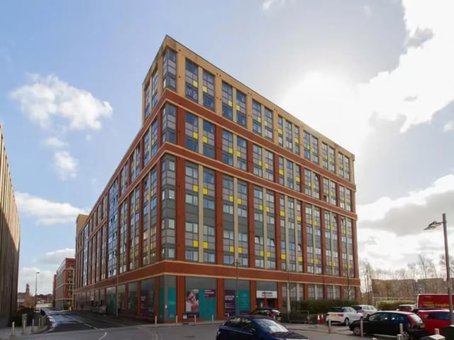 Modern building with many windows and cars outside exterior at Collegelands in Glasgow Student Accommodation
