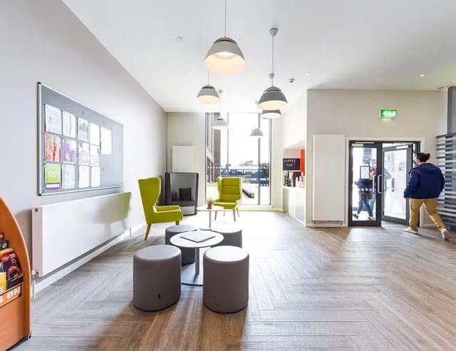 Communal seating area with noticeboard and exit living room at Merchant Studios in Glasgow Student Accommodation