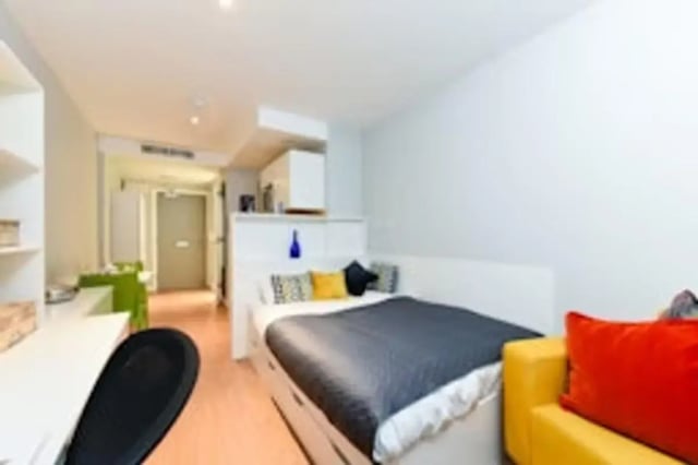 Bed desk yellow sofa and kitchen bedroom at Merchant Studios in Glasgow Student Accommodation