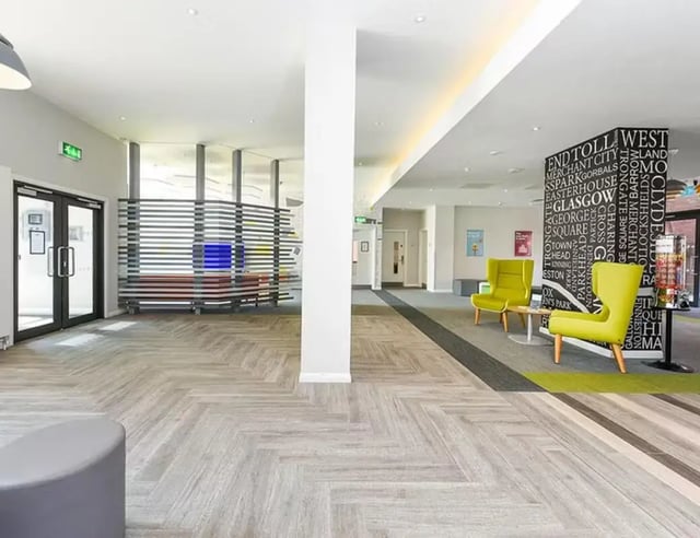 Modern lobby with lime chairs and city names wall at Merchant Studios in Glasgow Student Accommodation