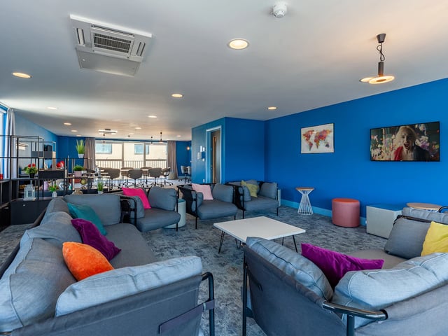 Modern common area with couches and tables living room at West Way Square in Oxford Student Accommodation
