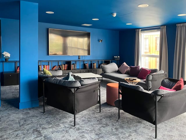 Sofas and television in blue room living area at West Way Square in Oxford Student Accommodation