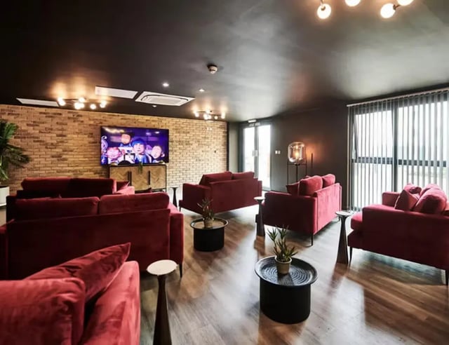 Red sofas television brick wall living room at St Davids in Swansea Student Accommodation