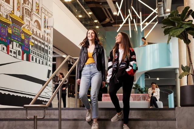 Two women on stairs with mural communal area at Horizon Heights in Liverpool Student Accommodation