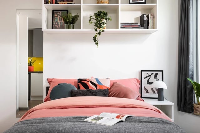 Bed with pink bedding and shelves Bedroom at Horizon Heights in Liverpool Student Accommodation
