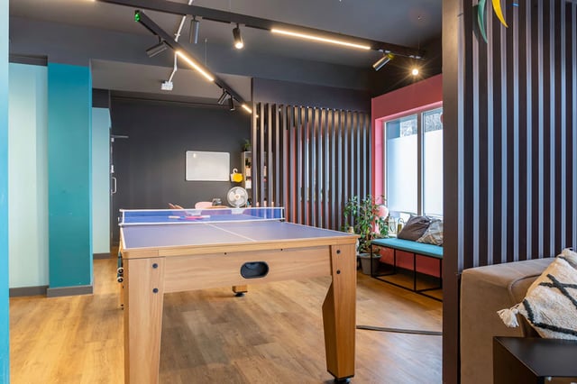 Ping pong table whiteboard fan bench living area at St Augustine's House in Plymouth Student Accommodation