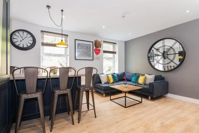 Bar stools couch coffee table clock living area at Bankfield in Huddersfield Student Accommodation