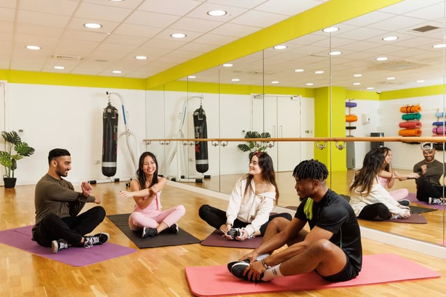Students stretching on yoga mats in gym at Drapery Place in London Student Accommodation