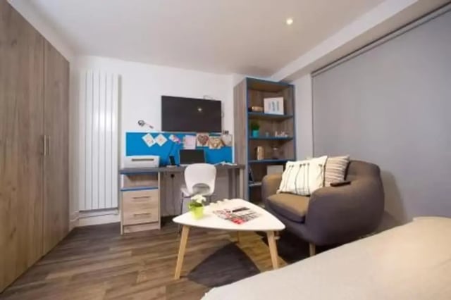 Desk printer chair TV bookshelf armchair coffee table bedroom at Edge Apartments in Birmingham Student Accommodation