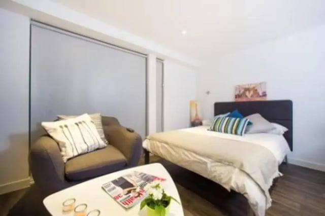 Armchair bed coffee table with magazines bedroom at Edge Apartments in Birmingham Student Accommodation