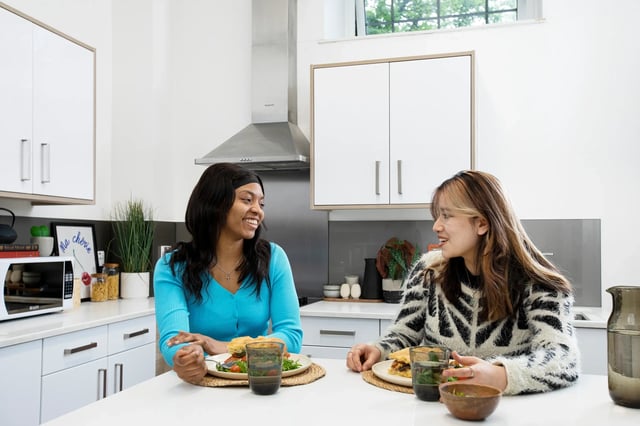 Two students eating in a modern kitchen kitchen at Arbour House in London Student Accommodation
