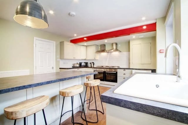 Kitchen island with stools oven stovetop and sink kitchen at 131 Hyde Park in Leeds Student Accommodation