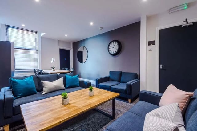 Modern living room with blue sofas clock mirror living room at 9 Manor Drive in Leeds Student Accommodation