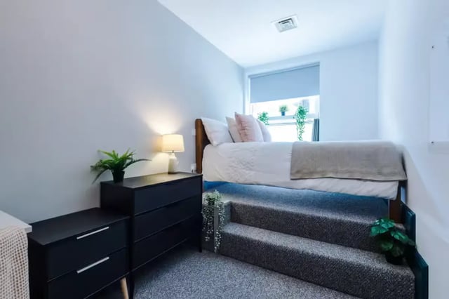 Bed with dresser and stairs bedroom at The Shoe & Boot Factory in Leicester Student Accommodation