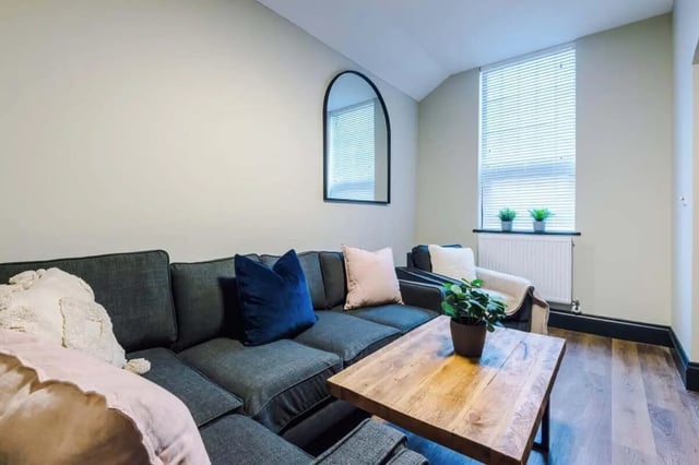 Dark sectional sofa with pillows and wooden table Living room at The Hosiery in Leicester Student Accommodation