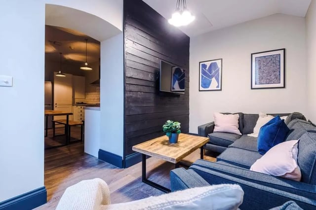 Dark wood wall sectional sofa artwork living room at The Hosiery in Leicester Student Accommodation