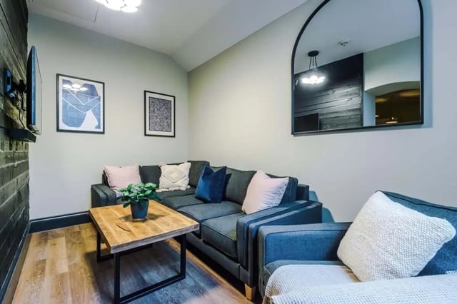 Gray sectional sofa with pillows wooden coffee table living room at The Hosiery in Leicester Student Accommodation