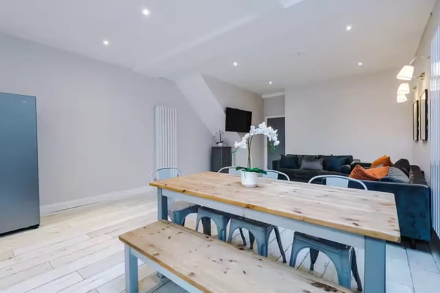 Dining table with benches and sofa living room at 86 Woodcroft Road in Liverpool Student Accommodation
