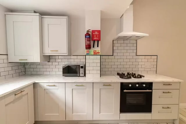 White cabinets microwave oven gas hob oven kitchen at 74 Woodcroft Road in Liverpool Student Accommodation