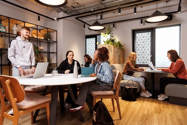 Students working and chatting around a table living room at Artisan Heights in Manchester Student Accommodation