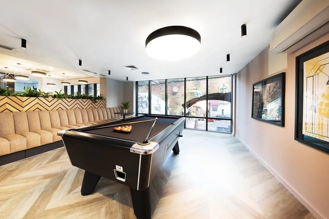 Pool table with balls and cues sofa lounge area Living room at Artisan Heights in Manchester Student Accommodation