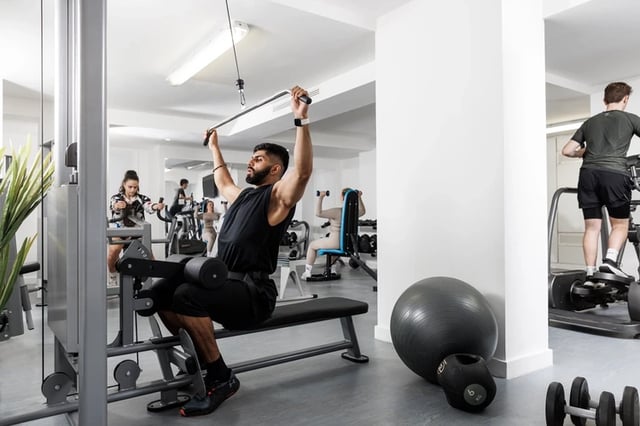 Gym equipment with people exercising fitness area at Bridgewater Heights in Manchester Student Accommodation
