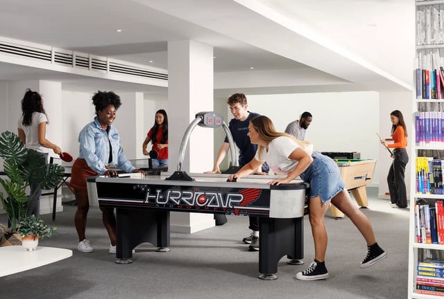 Students playing air hockey and pool gaming area at Bridgewater Heights in Manchester Student Accommodation