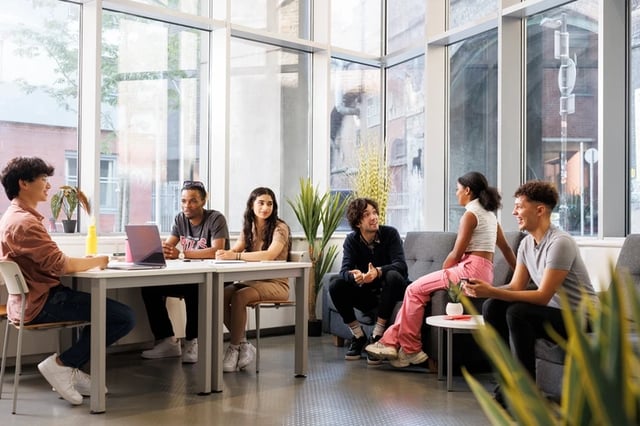 Students collaborate at tables and on sofas communal area at Bridgewater Heights in Manchester Student Accommodation