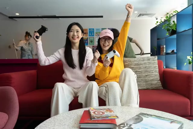 Two students playing video games on sofa living room at Scape Aurora in Melbourne Student Accommodation