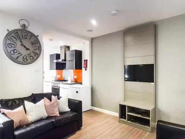 Black sofa large wall clock kitchen living room at 128 Ashford Street in Stoke-On-Trent Student Accommodation