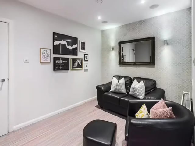 Black sofas ottoman framed art mirror living room at 219 Leek Road in Stoke-On-Trent Student Accommodation