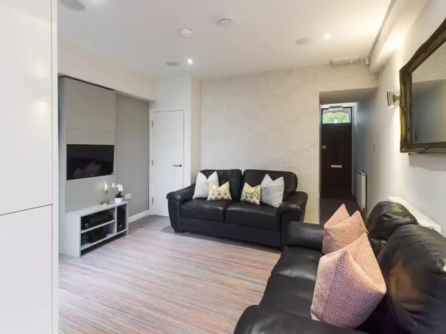 Black leather sofas TV cabinet striped floor living room at 233 Leek Road in Stoke-On-Trent Student Accommodation