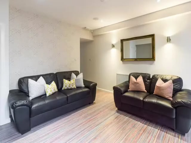 Two black couches with patterned pillows living room at 233 Leek Road in Stoke-On-Trent Student Accommodation