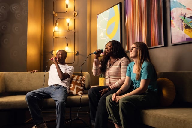 Students singing karaoke on sofa living room at Bromley Place in Nottingham Student Accommodation