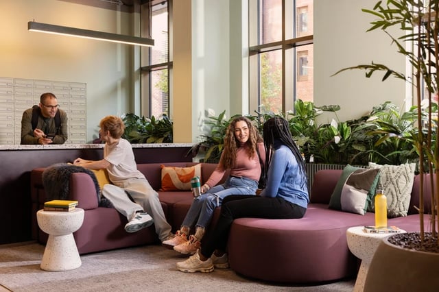 Students on purple couch by mailboxes living room at Bromley Place in Nottingham Student Accommodation
