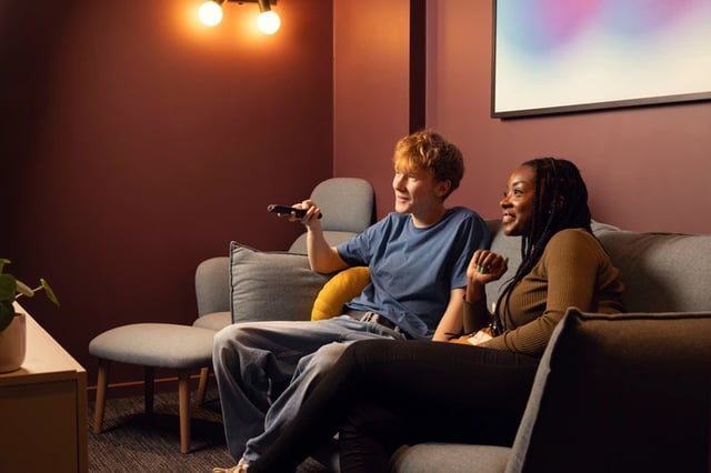 Two students watching TV on sofa living room at Bromley Place in Nottingham Student Accommodation