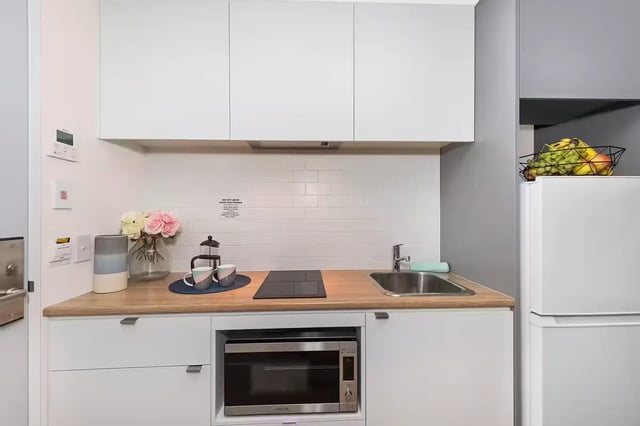 Countertop sink microwave stovetop and fridge kitchen at Scape Waymouth in Adelaide Student Accommodation