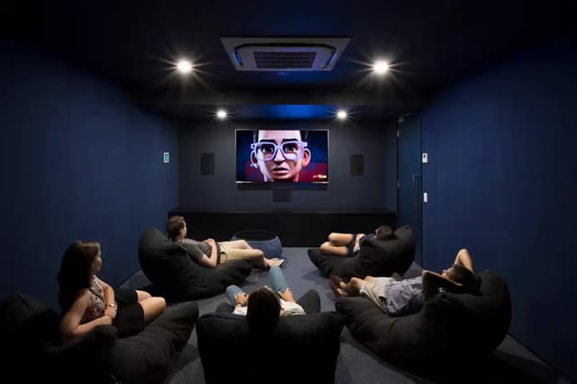 Students relax on beanbags watching a movie screen cinema room at Scape Waymouth in Adelaide Student Accommodation