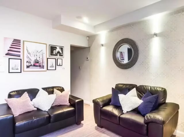Two black leather sofas with patterned pillows living room at 125 Ashford Street in Stoke-On-Trent Student Accommodation