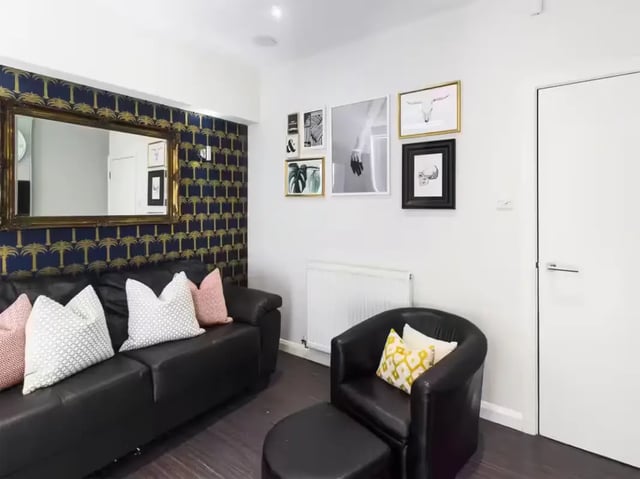 Black sofa armchair ottoman wall art living room at 41 Guildford Street in Stoke-On-Trent Student Accommodation