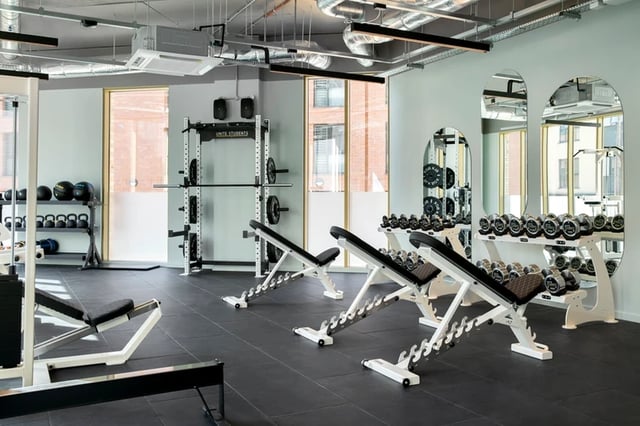 Gym with weight racks benches and dumbbells gym area at Morriss House in Nottingham Student Accommodation