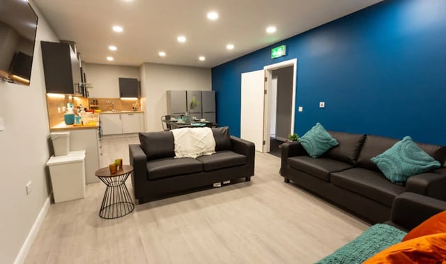 Two sofas kitchen area and dining table living area at Electric Press in Sheffield Student Accommodation
