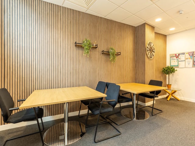 Wooden tables chairs plants clock study area at Straits Manor in Sheffield Student Accommodation