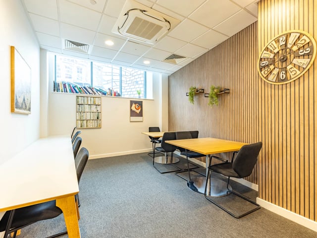 Study area with tables chairs books and clock at Straits Manor in Sheffield Student Accommodation